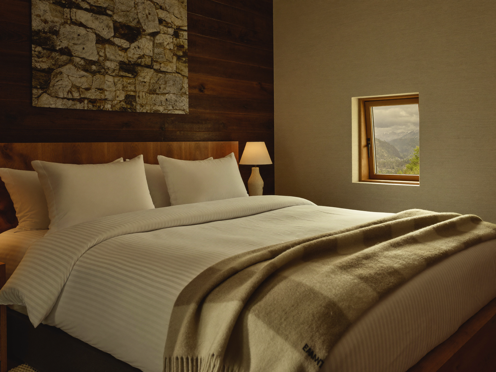 Chambre de chalet préparée aux standards hôteliers, literie blanche et plaid sauge