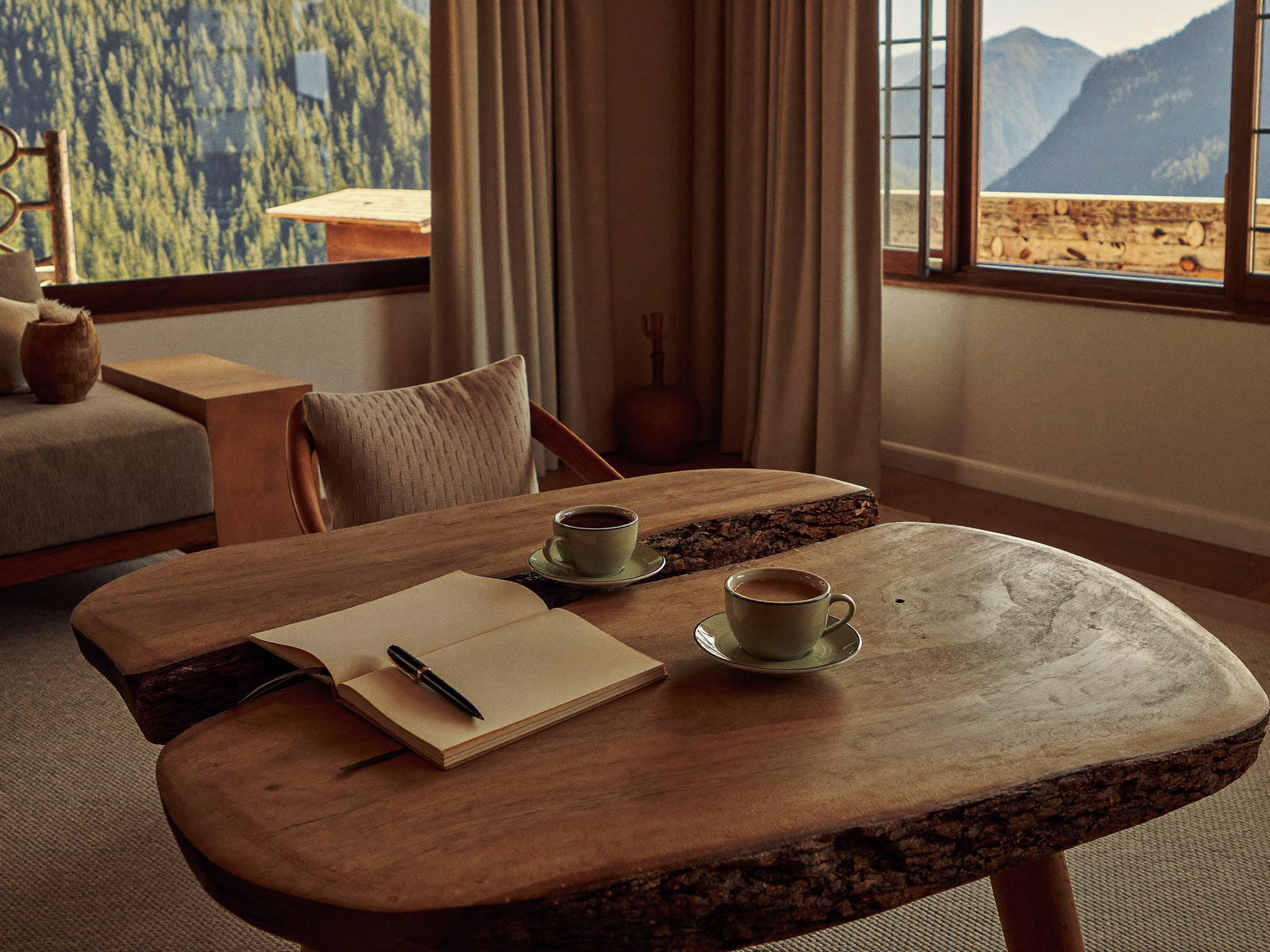 Deux tasses de café et un carnet sur une table de chalet