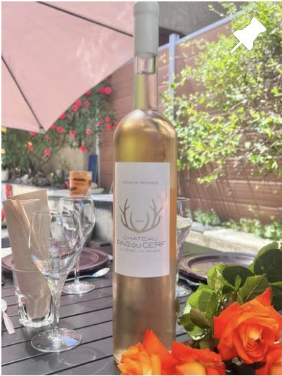 Bouteille de rosé dressée en terrasse, verres et roses
