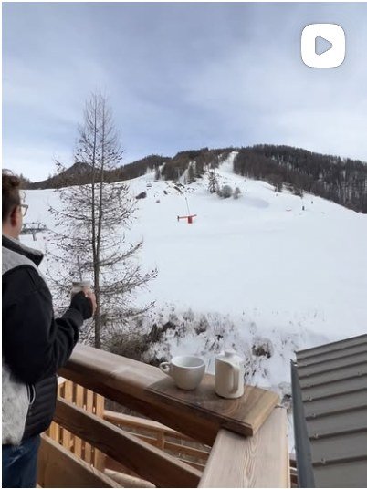 Balcon face aux pistes, tasses posées sur la rambarde